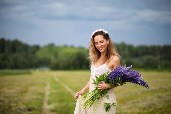一个美丽的女孩 带着一束蓝色的自然花朵 — 图库照片