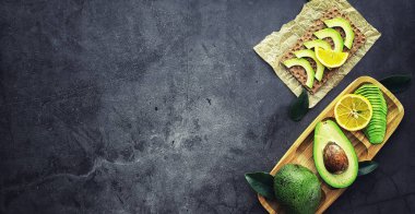 Avokado yemek tarifleri. Tahta kesme tahtasında servis edilen olgun yeşil avokado..