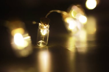 Cam şişelerden oluşan Noel çelengi, içinde bitki olan kavanozlar. Yeni yıl ve Noel konsepti. Ampullerden bir çelenk Güzel bir ışık ve boke