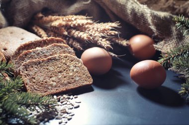 Siyah bir masada buğday ve glüten ile taze somun ekmek. Fırın ve market konsepti. Taze, sağlıklı çavdar ve beyaz somun ekmeği, çuval bezi üzerine serpiştirilmiş un. Tahıllı taze ev yapımı ekmek..