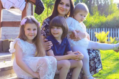 Genç, büyük bir aile yaz sabahı yürüyüşünde. Parkta oynayan çocuklu güzel anne..