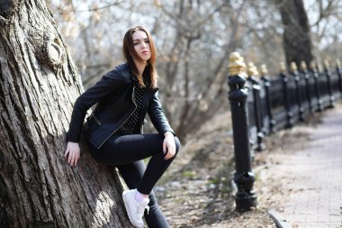 Bahar şehrinde güneşli bir havada yürüyen bir kız.