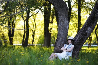 Güneşli bir günün akşamında parkta bir kız.
