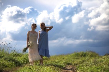 Genç kızlar tarlada Rai 'den önce yürüyor.