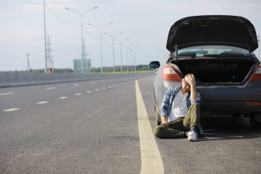 Yoldaki bir arabanın tekerleğini değiştirmek. Kenarda lastik işi yapan bir adam..