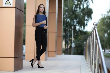 Modern bir binanın yakınındaki bir iş toplantısında belgeli bir kız.