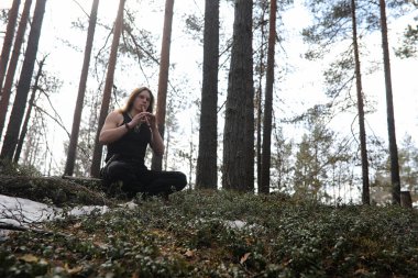 Doğada bir araçla bir müzisyen. Adam bir çam ormanı içinde bir flüt çalıyor. Bahar ormanda Druids müzik