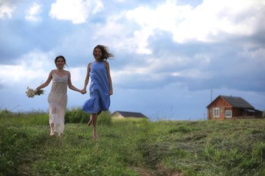 Genç kızlar tarlada Rai 'den önce yürüyor.