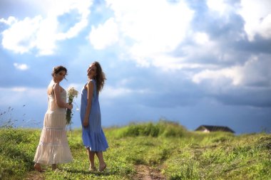 Genç kızlar tarlada Rai 'den önce yürüyor.