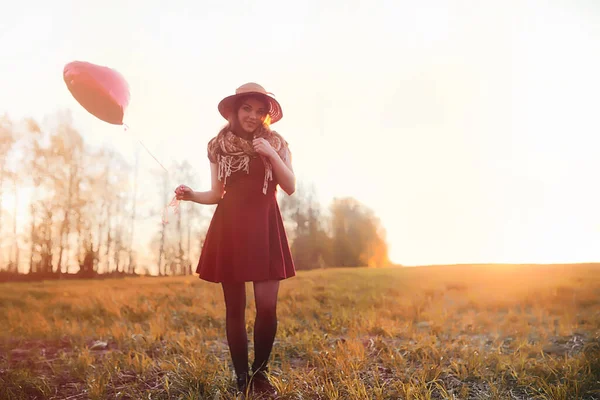 公園の散歩中の帽子の少女 秋に籠を持った女の子が歩いている 女の子は日没時に道路を歩いている — ストック写真