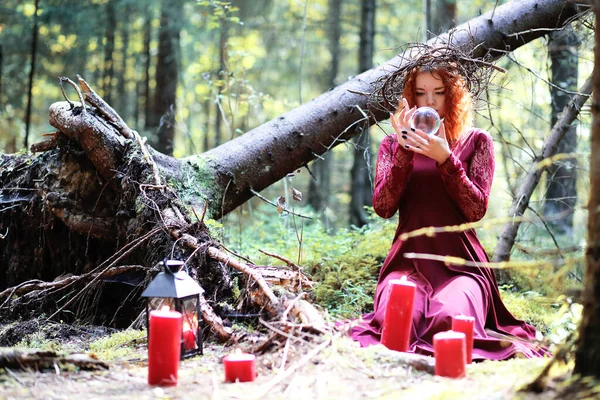 红头发的女巫拿着一个仪式 有一个水晶球在前 — 图库照片