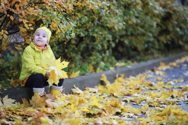 Çocuklar sonbahar parkında sonbaharda yürürler