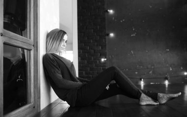 Genç bir kız büyük bir apartman dairesinde dinleniyor.