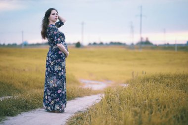 Doğada giyinmiş hamile bir kız.