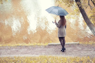 Sonbahar parkında montlu genç kız.