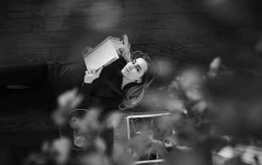 Genç bir kız büyük bir apartman dairesinde dinleniyor.