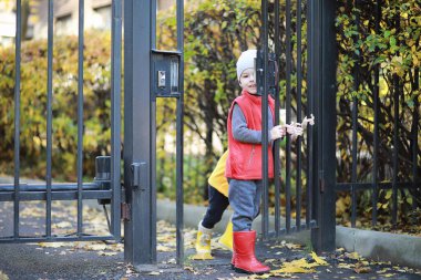 Çocuklar sonbaharda sonbahar parkında yürür