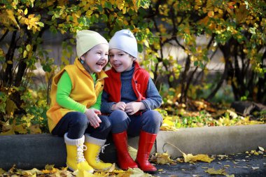 Çocuklar sonbaharda sonbahar parkında yürür