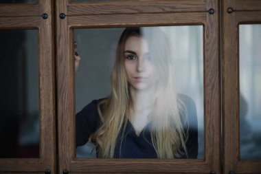 Genç bir kız büyük bir apartman dairesinde dinleniyor.