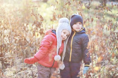Çocuklar sonbahar parkında sonbaharda yürürler