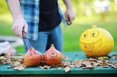 Sonbahar gelenekleri ve Cadılar Bayramı hazırlıkları. Doğada bir ev, masada balkabağından yapılmış bir lamba kesilir..