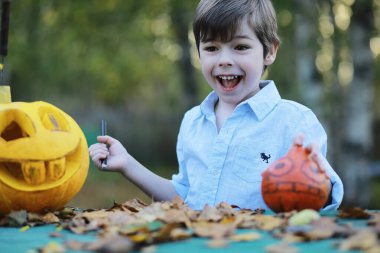 Sonbahar gelenekleri ve Cadılar Bayramı hazırlıkları. Doğada bir ev, masada balkabağından yapılmış bir lamba kesilir..