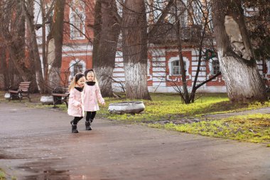 Genç bir aile güneşli bir günde sonbahar parkında yürüyüş yapıyor. Birlikte olmanın mutluluğu..