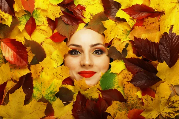 Artistic conceptual autumn portrait. Colorful leaves. Leaves of trees around emotional face. Autumn is coming.