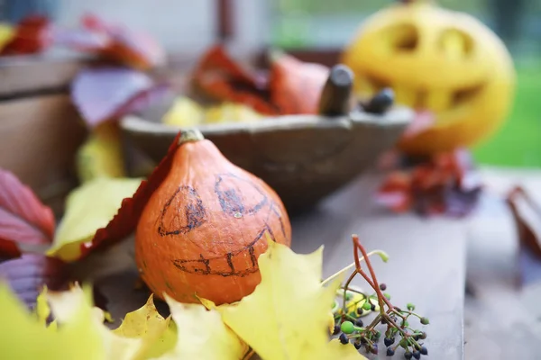 Autumn traditions and preparations for the holiday Halloween. A house in nature, a lamp made of pumpkins is cut out at the table.