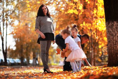 Yaprak parkta düşer. Sonbahar parkında yürüyüşe çıkmış çocuklar. - Aile. Düş! Mutluluk.