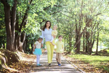 Çocuklarla birlikte yaz parkında yürüyüş yapan bir aile. Sonbahar parkı yaklaşıyor. - Aile. Düş! Mutluluk. 
