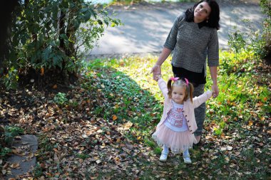 Yaprak parkta düşer. Sonbahar parkında yürüyüşe çıkmış çocuklar. - Aile. Düş! Mutluluk.