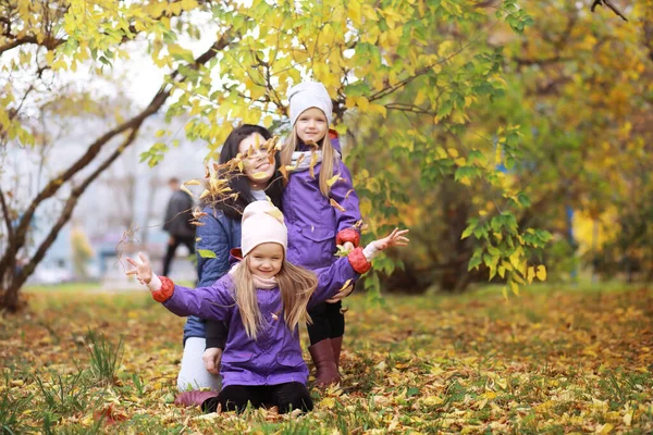 阳光明媚的日子 年轻的一家人在秋天的公园里散步 幸福的在一起 — 图库照片