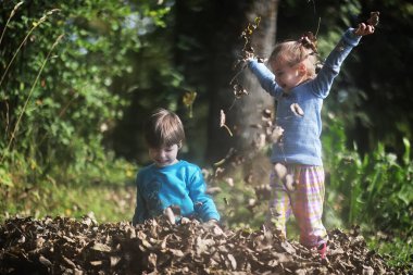 Yaprak parkta düşer. Sonbahar parkında yürüyüşe çıkmış çocuklar. - Aile. Düş! Mutluluk.