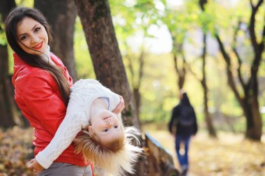 Sonbahar parkında yürüyüşe çıkmış çocuklar. Yaprak parkta düşer. - Aile. Düş! Mutluluk.