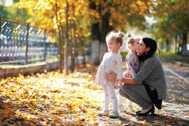 Yaprak parkta düşer. Sonbahar parkında yürüyüşe çıkmış çocuklar. - Aile. Düş! Mutluluk.