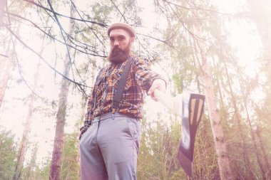 Büyük bir balta ile sakallı bir oduncu ağaç felling önce inceler