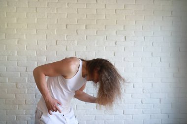 Uzun saçlı genç adam dalgasını sallıyor.