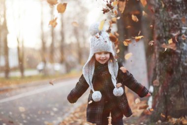 Çocuklar sonbahar parkında sonbaharda yürürler