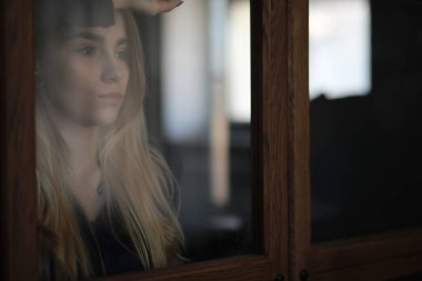 Genç bir kız büyük bir apartman dairesinde dinleniyor.