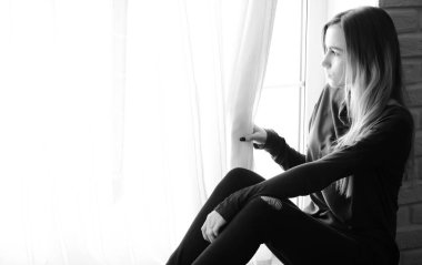 Genç bir kız büyük bir apartman dairesinde dinleniyor.