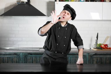 Adam mutfak masasında sebze pişiriyor.