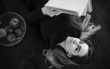 Genç bir kız büyük bir apartman dairesinde dinleniyor.