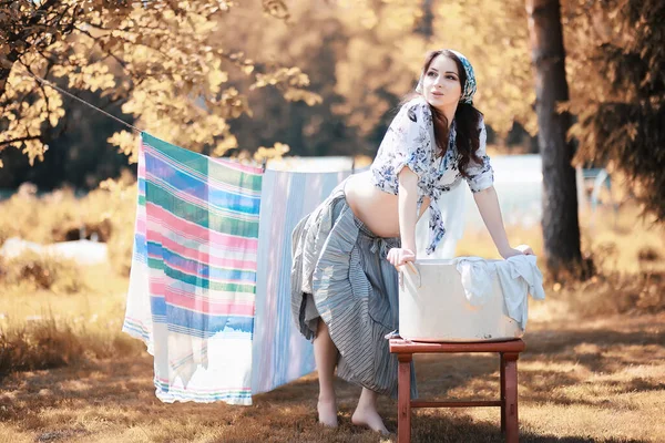 妊娠中の女性乾燥のためのロープにシーツをぶら下げ — ストック写真