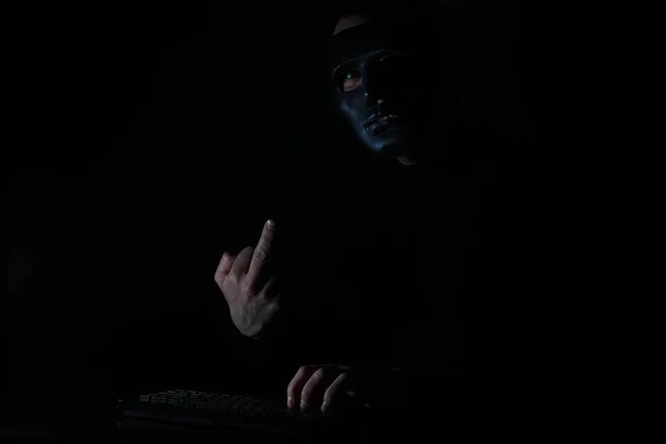 一个戴面具的人在达尔的桌子旁的键盘上打印 — 图库照片