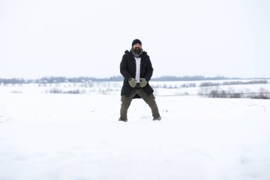 Kış ormanlarında sakallı adam. Çekici, mutlu, sakallı genç bir adam parkta yürüyor..