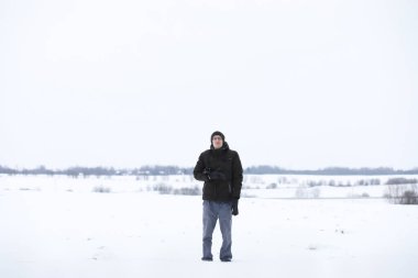 Kış ormanlarında sakallı adam. Çekici, mutlu, sakallı genç bir adam parkta yürüyor..