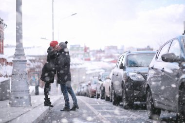 Genç bir çift kış şehrinde yürüyor.
