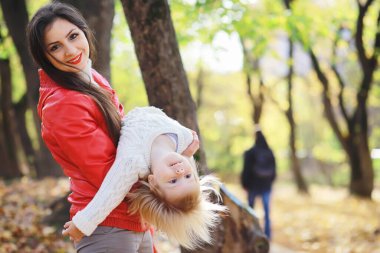 Sonbahar parkında yürüyüşe çıkmış çocuklar. Yaprak parkta düşer. - Aile. Düş! Mutluluk.
