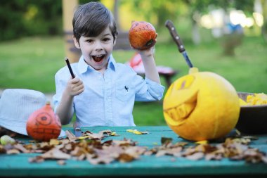 Sonbahar gelenekleri ve Cadılar Bayramı hazırlıkları. Doğada bir ev, masada balkabağından yapılmış bir lamba kesilir..